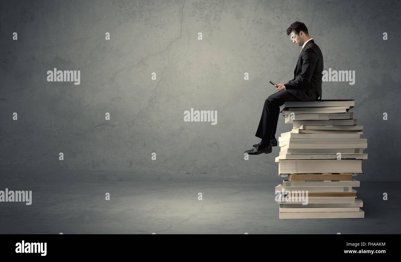 Student sitting on pile of books Stock Photo - Alamy