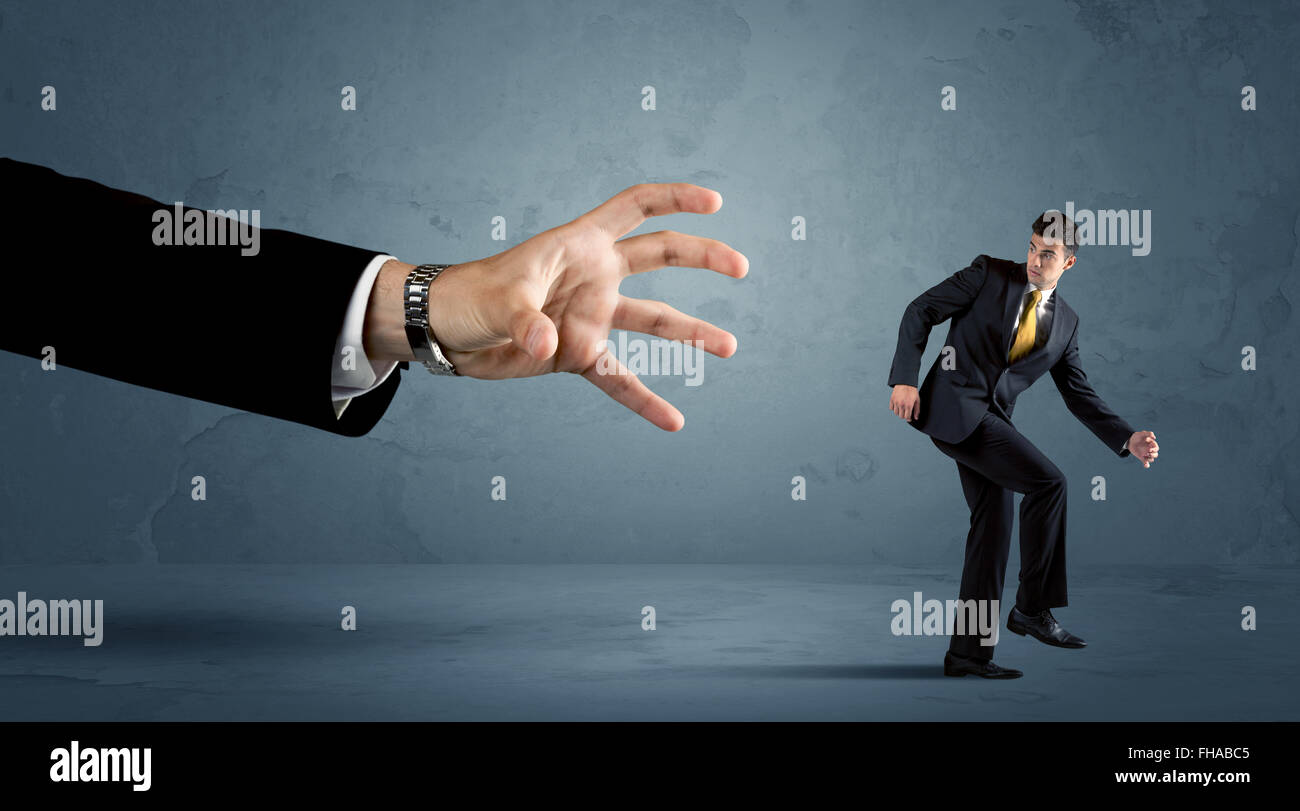 Business man running away from a huge hand concept Stock Photo - Alamy