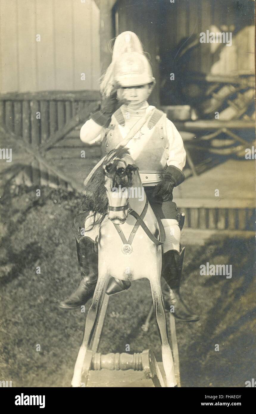 Portrait postcard of  boy dressed in uniform on rocking horse Stock Photo