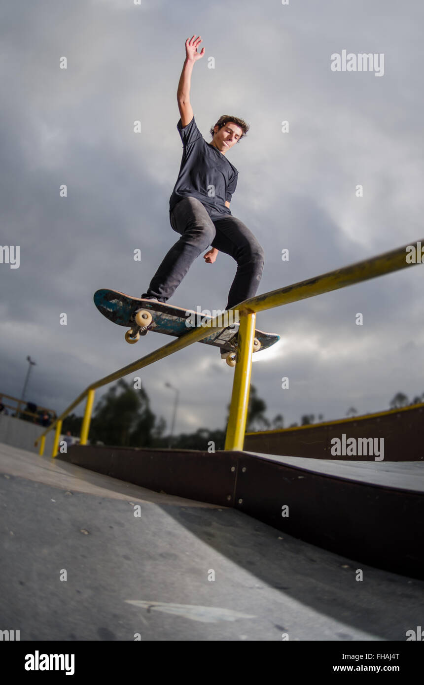 Skateboarder doing a board slide over the rail at the skate park Stock
