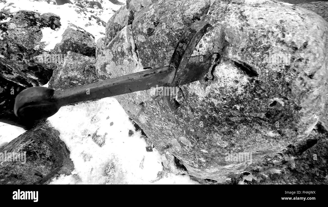 legendary Excalibur sword into the stone in the middle of the forest in winter Stock Photo