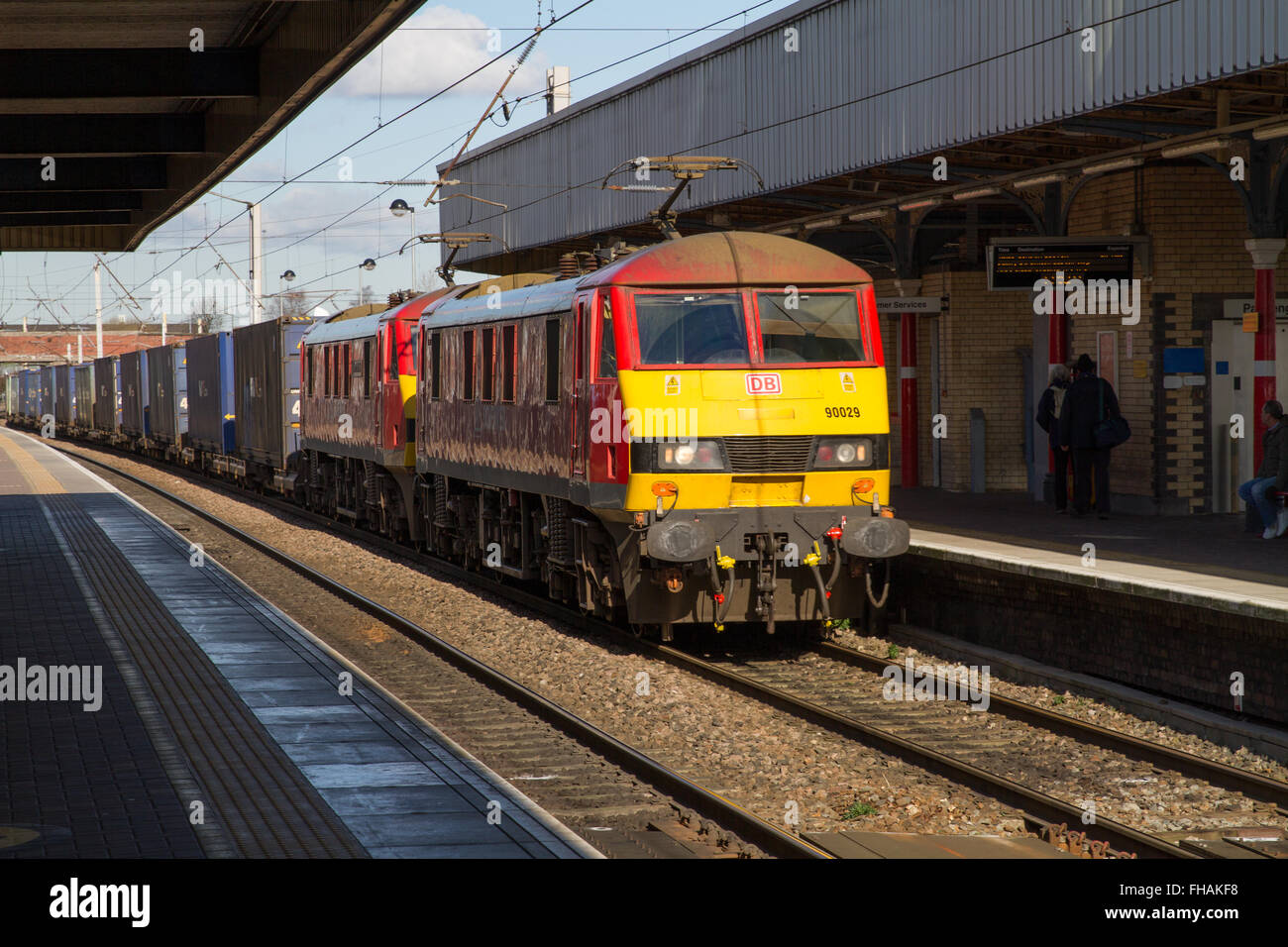 DB Cargo Container Freight Train at Warrington Bank Quay hauled by two Electric Locomotives in DB Red livery in bright sunshine, Warrington, England. Stock Photo
