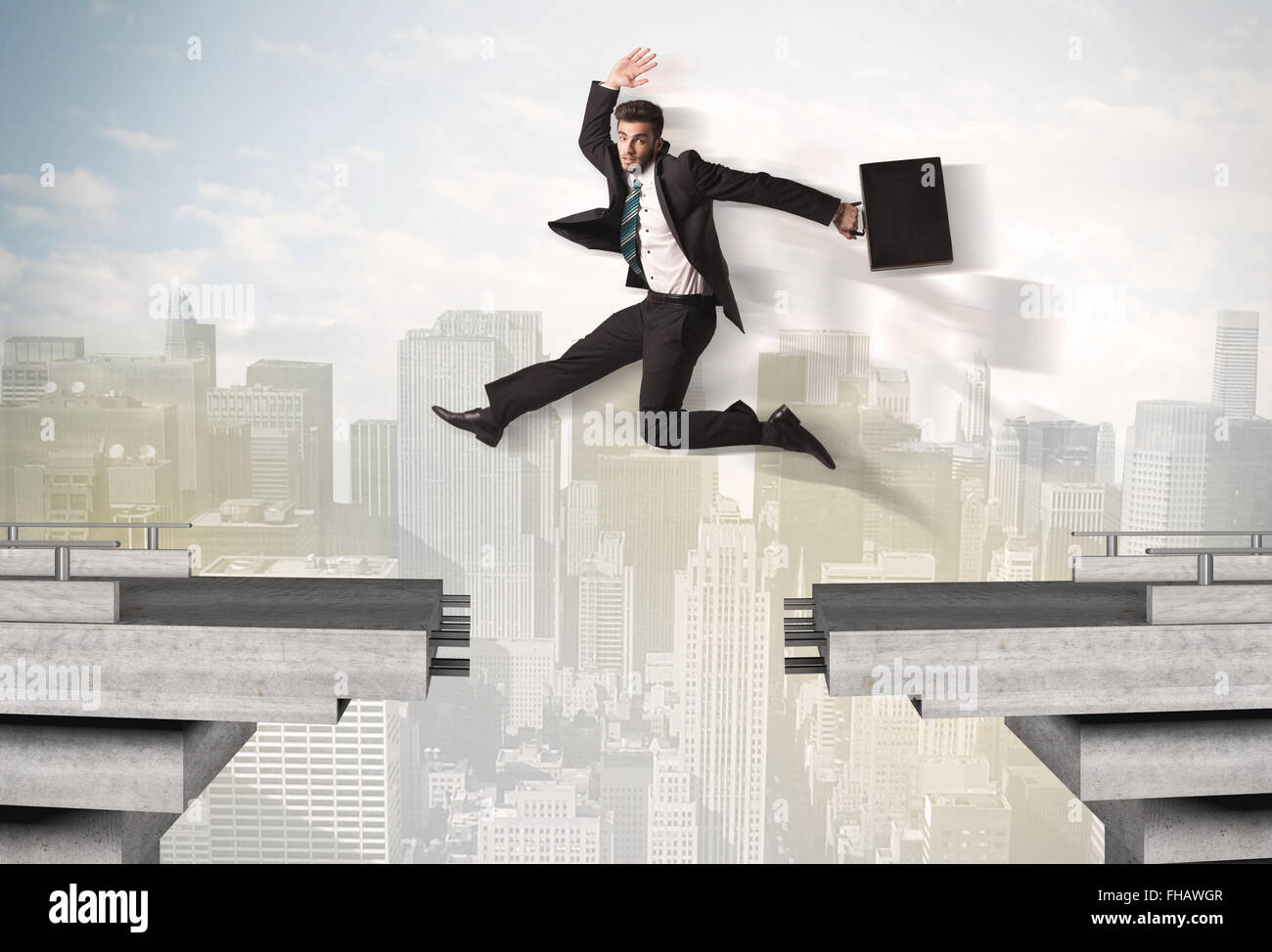 Energetic business man jumping over a bridge with gap Stock Photo