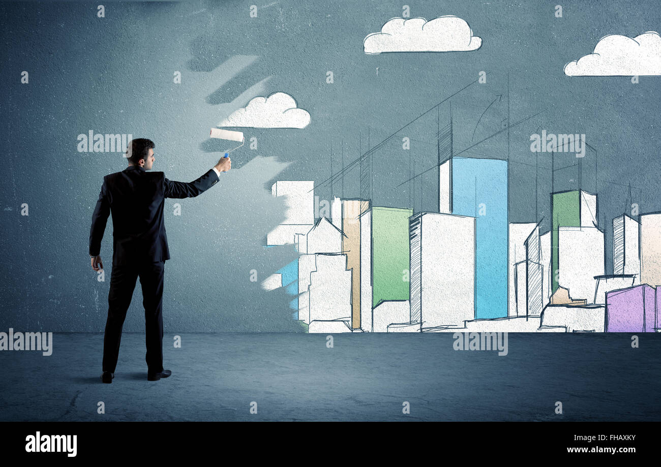 Salesman painting tall buildings on urban wall Stock Photo Alamy