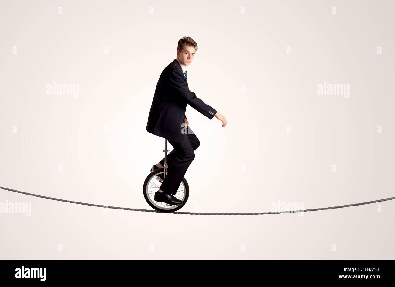 Extreme business man riding unicycle on a rope Stock Photo Alamy