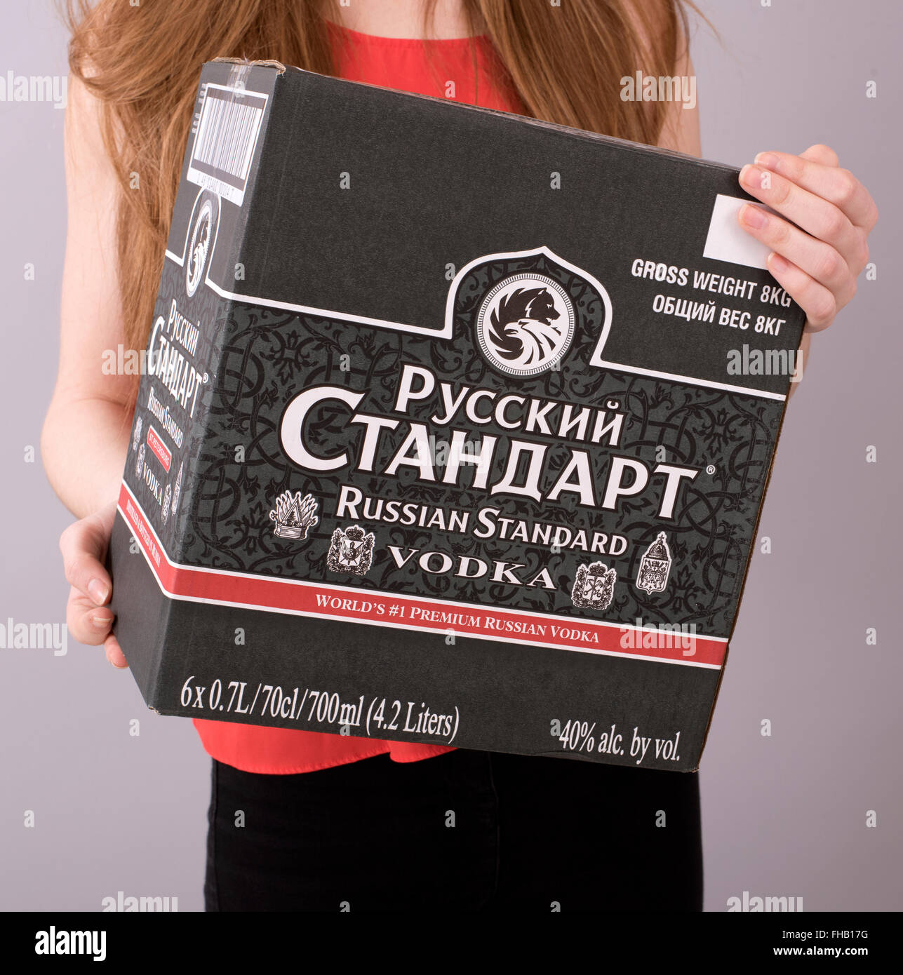 Young woman carrying a box of Russian Vodka Stock Photo