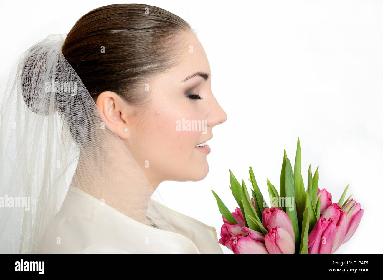 Young bride with white veil. side-face photo of female model with tulips. Stock Photo