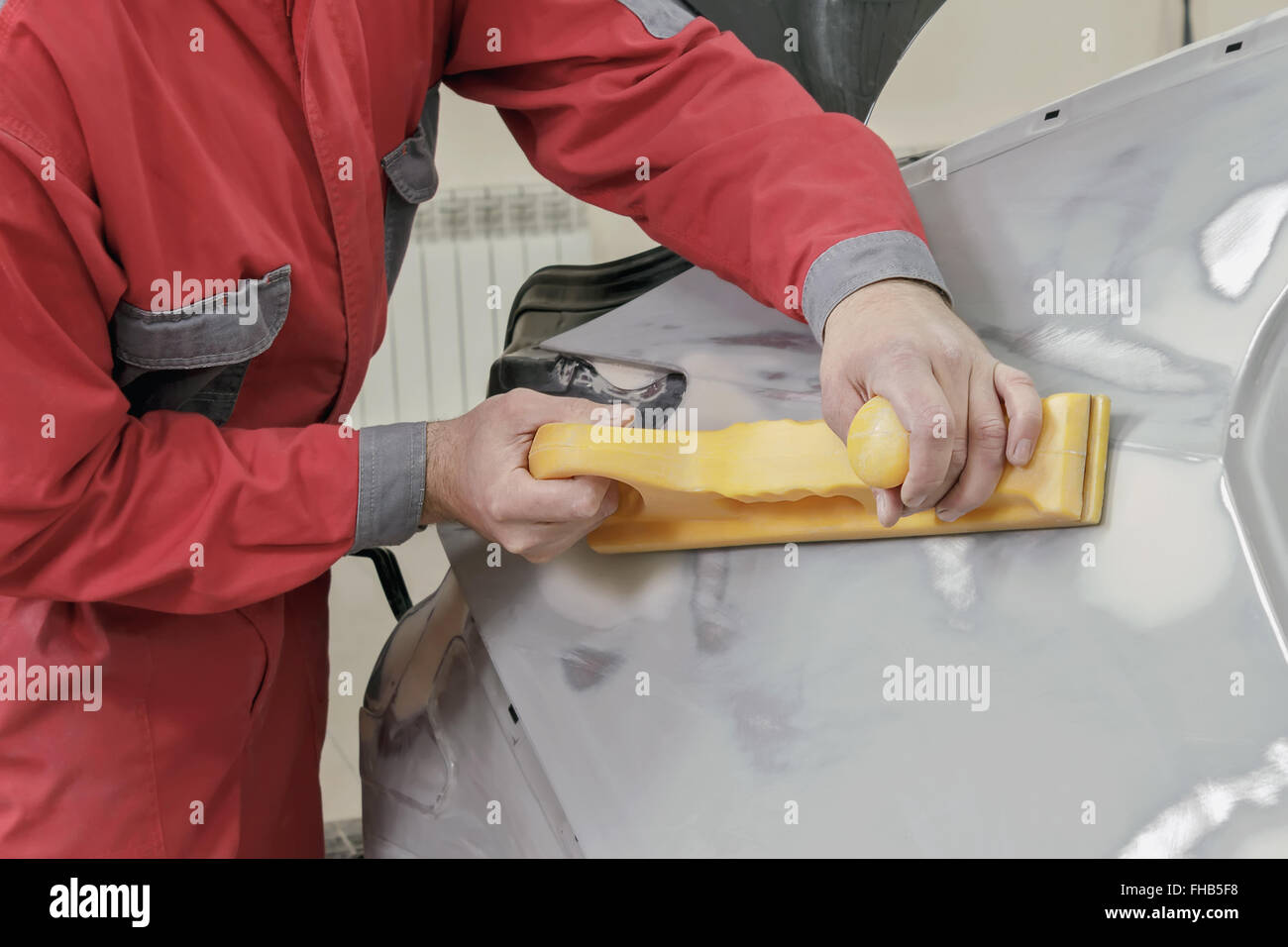 Car painter prepares the rear wing of the car for painting. Stock Photo