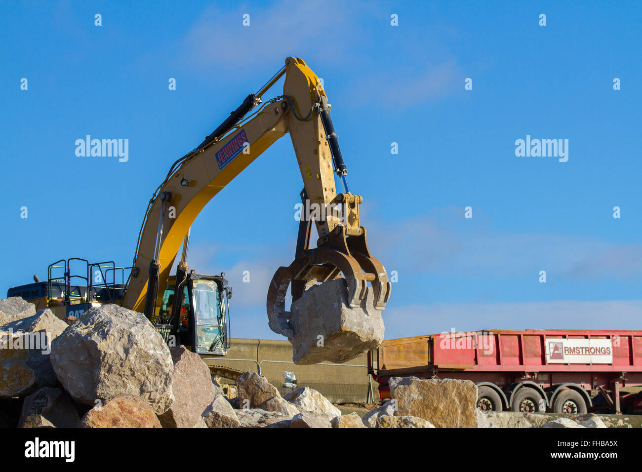 Blackpool, Fleetwood, Lancashire, UK. 24th February, 2016. Rossall Coastal defence £86million project resumes.  After recent storms and high winds, rock placement continues on the revetment at the southern end of the works with an additional 9,500 tonnes of primary rock placed. Primary rock placement now totals 95,000 tonnes and 171,500 tonnes of it have now been delivered to site.  Cernan Elias/Alamy Live News Stock Photo