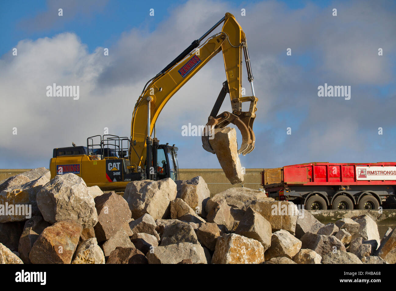 Blackpool, Fleetwood, Lancashire, UK. 24th February, 2016. Rossall Coastal defence £86million project resumes.  After recent storms and high winds, rock placement continues on the revetment at the southern end of the works with an additional 9,500 tonnes of primary rock placed. Primary rock placement now totals 95,000 tonnes and 171,500 tonnes of it have now been delivered to site.  Cernan Elias/Alamy Live News Stock Photo