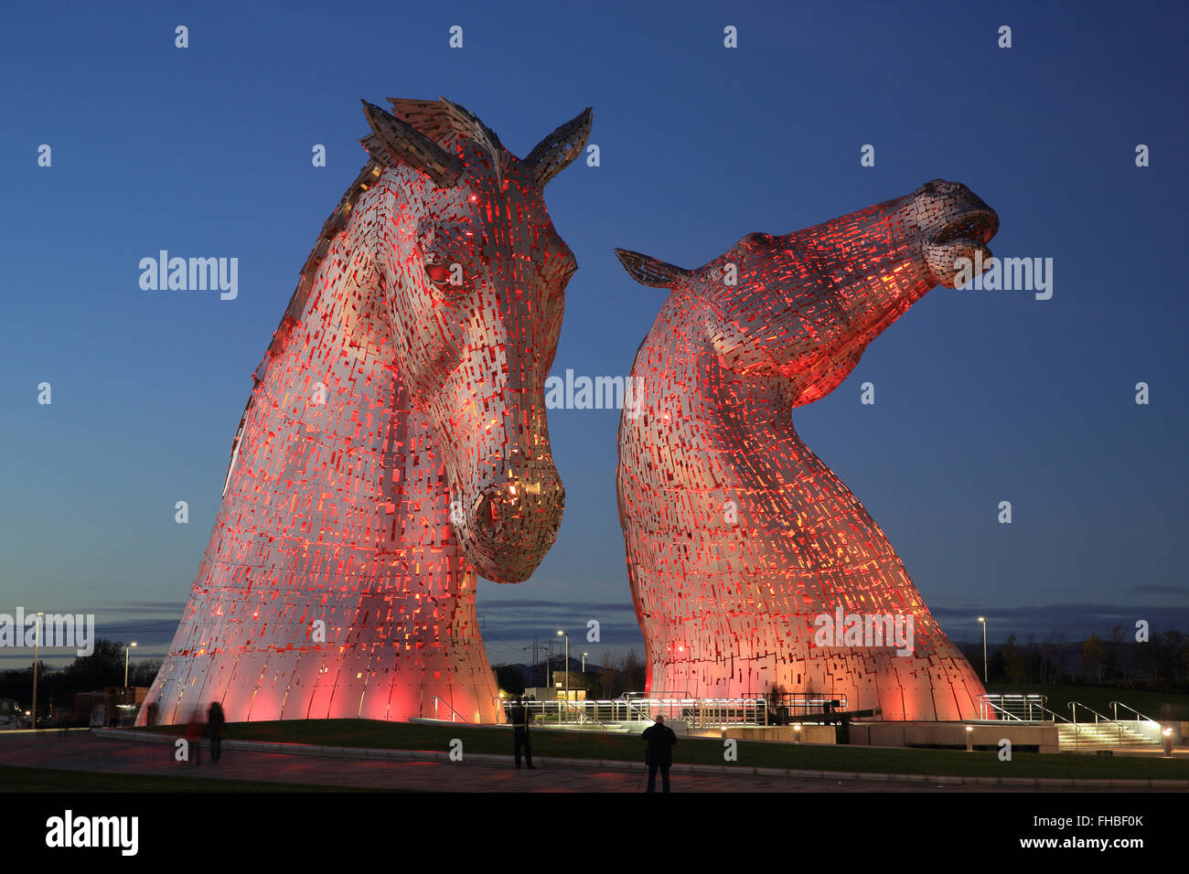 The Kelpies, the world's largest horse sculptures, illuminated red at dusk, in Falkirk, Scotland