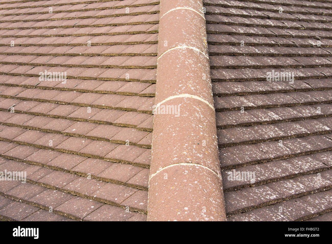 Semi circular hip ridge tiles on a hip roof on a house in the UK. Stock Photo