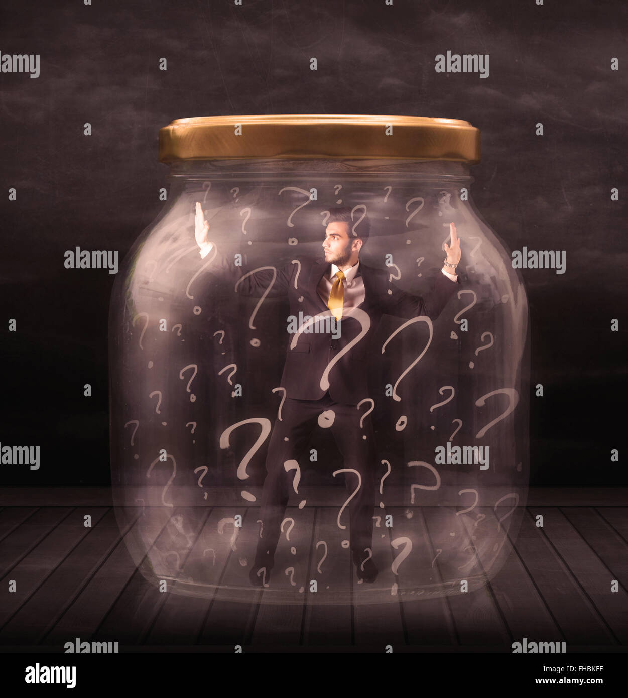 Businessman locked into a jar with question marks concept Stock Photo