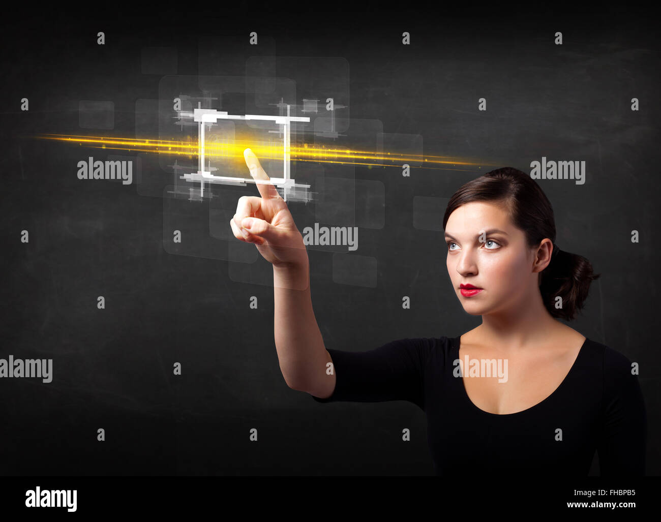 Young tech lady touching button with orange light beams concept Stock ...