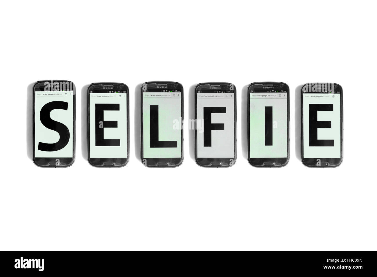 Selfie written on the screens of smartphones photographed against a white background. Stock Photo