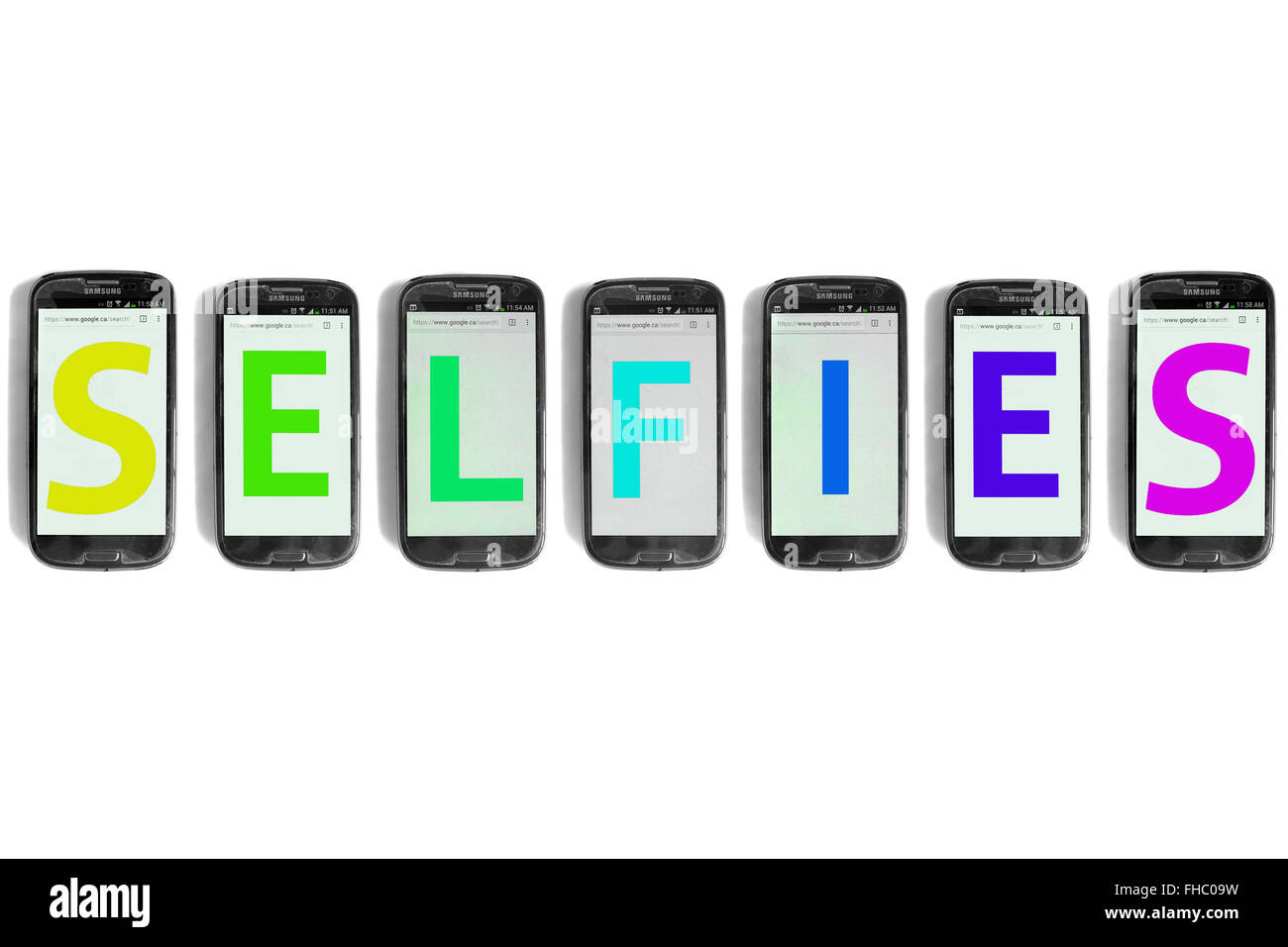 Selfies written on the screens of smartphones photographed against a white background. Stock Photo