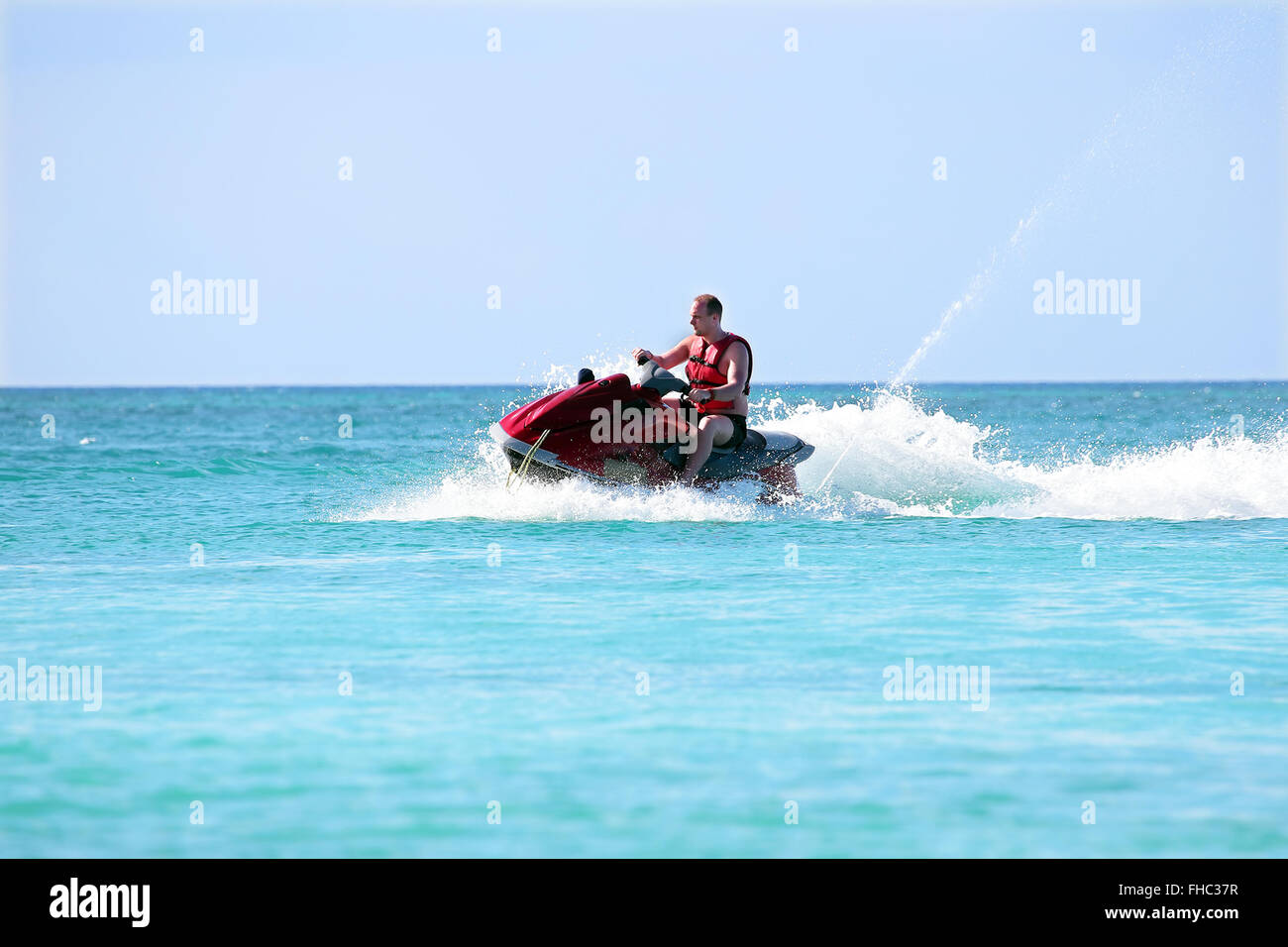 Young guy cruising on a jet ski on the caribbean sea Stock Photo