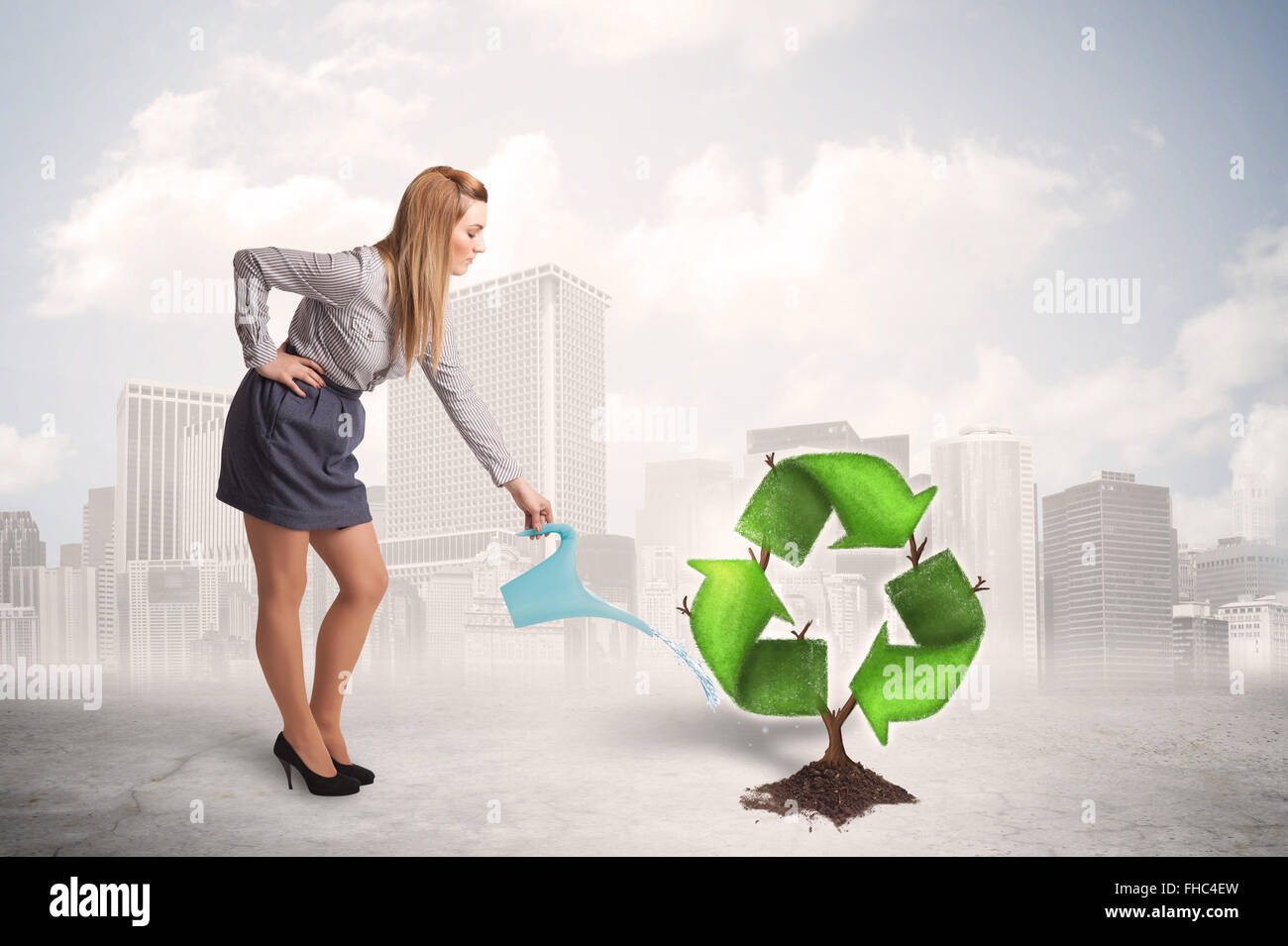 Business woman watering green recycle sign tree on city background Stock Photo