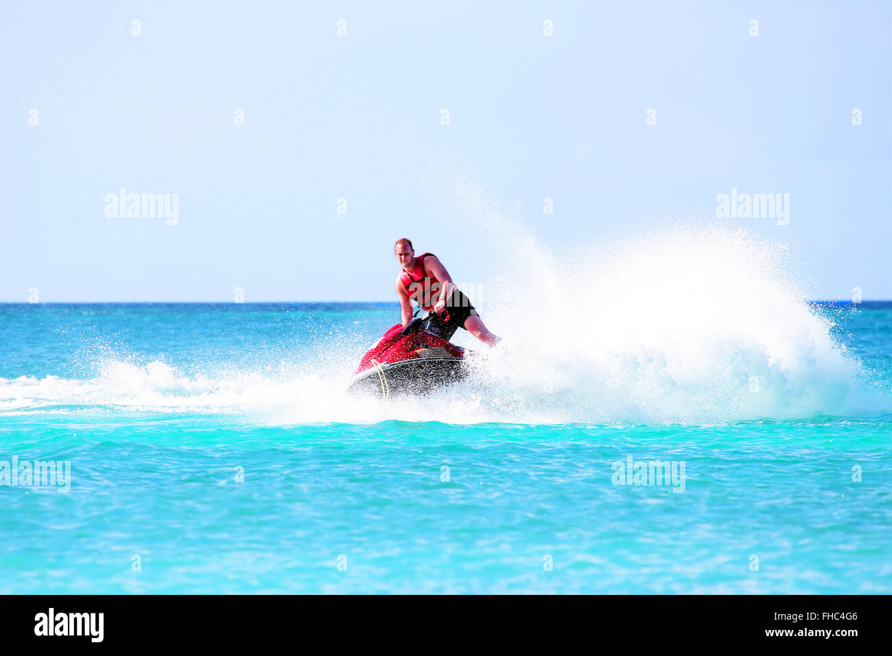 Young guy cruising on a jet ski on the caribbean sea Stock Photo