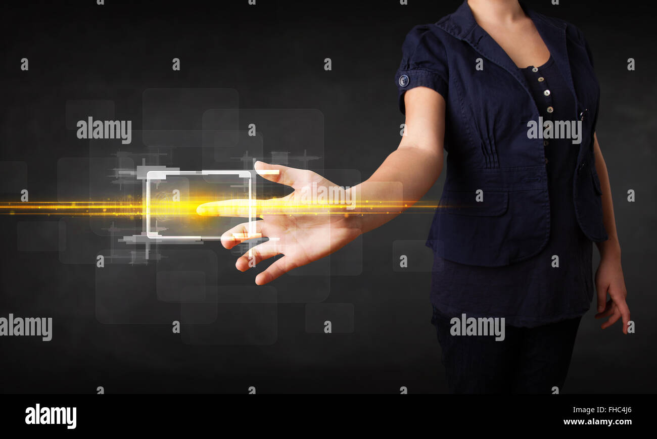Young tech lady touching button with orange light beams concept Stock ...