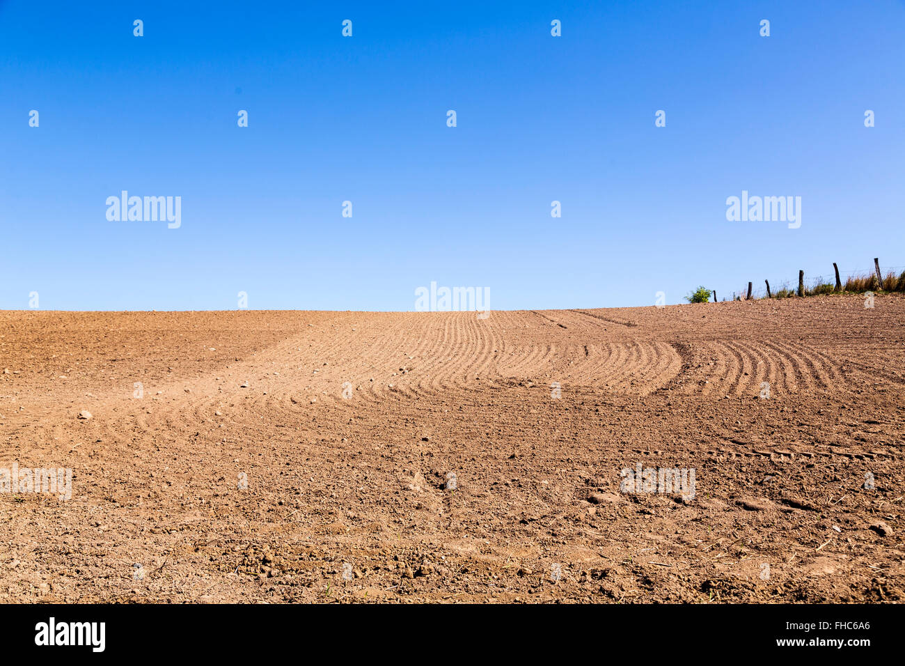 landscape with plowed field and blue sky Stock Photo - Alamy