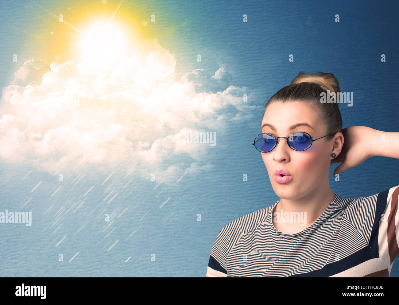 Young person looking with sunglasses at clouds and sun Stock Photo