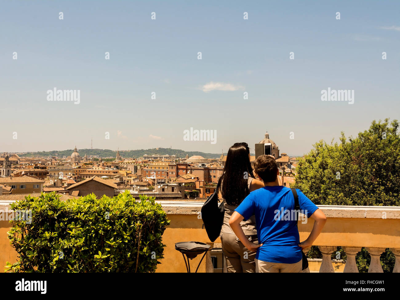 A woman and boy on a rooftop terrace on the Capitoline Hill, using a camera phone to take photos of Rome. Stock Photo