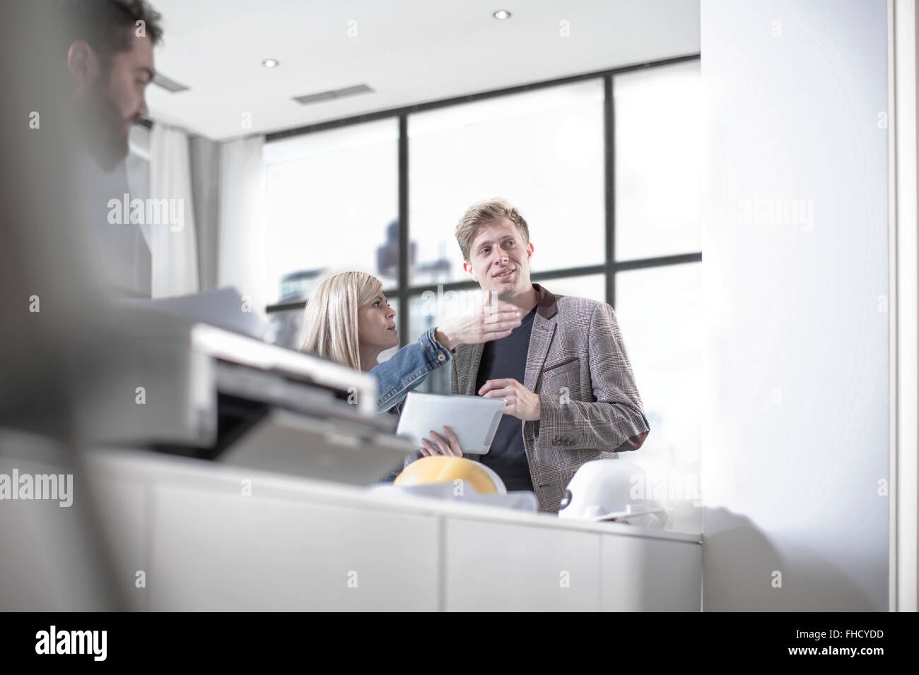 Woman talking to a man in office giving directions Stock Photo