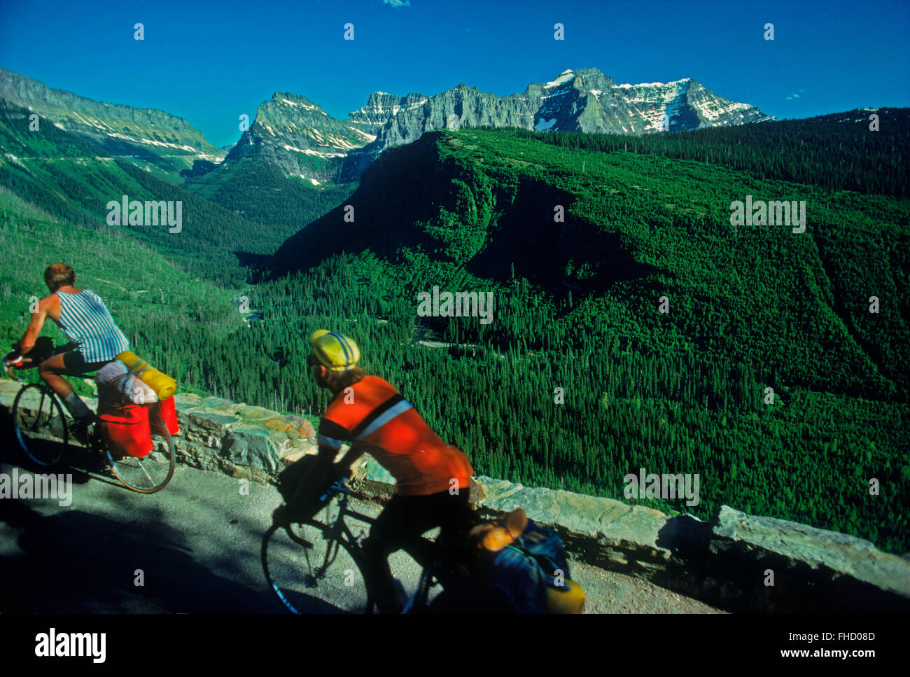 Two men with bicycles on route over Logan Pass also called Going-to-the-Sun Road in Glacier National Park in Montana USA Stock Photo