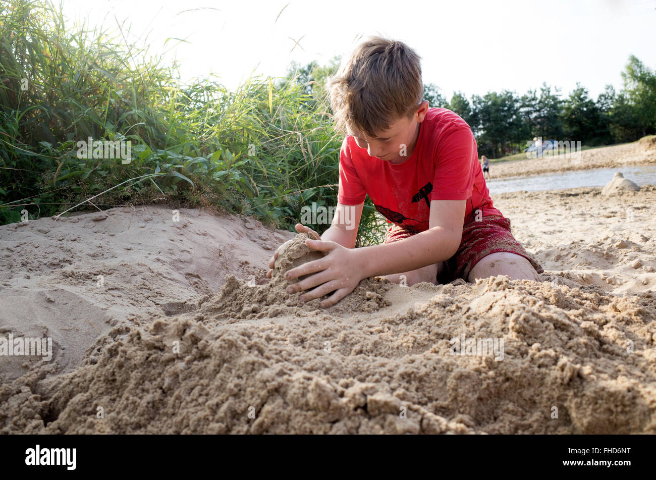 Boy age 10 constructing a sand castle. Rzeczyca Central Poland Stock Photo