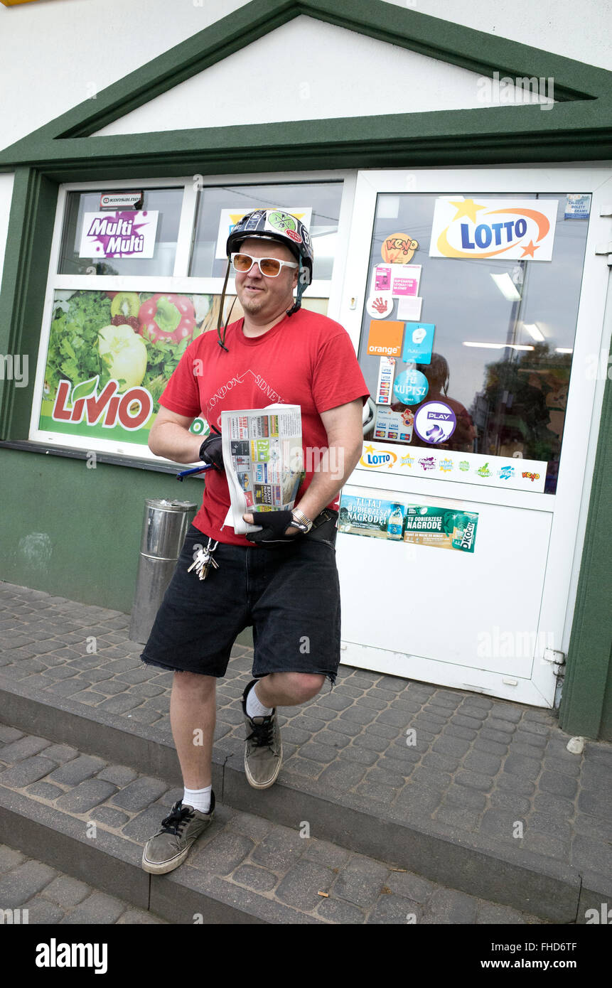 Man leaving Polish convenience store with something wrapped in a local newspaper. Rzeczyca Central Poland Stock Photo