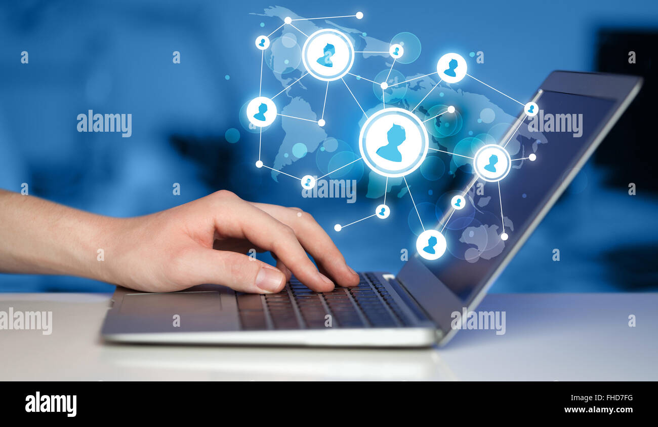 Close up of hand with laptop and social media icons Stock Photo - Alamy