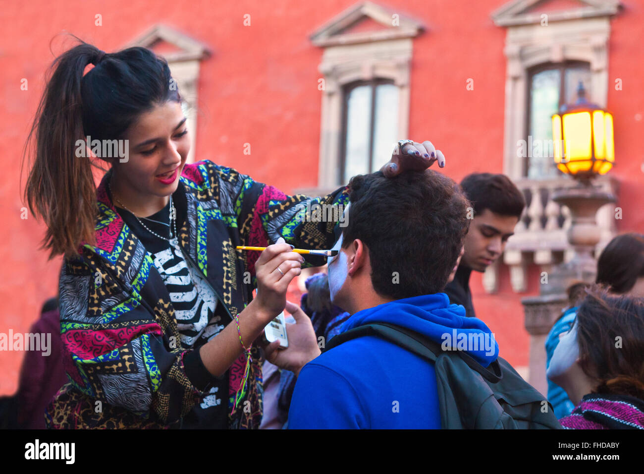 Faces are painted like skulls as people transform themselves into CATRINAS during DAY OF THE DEAD  -  SAN MIGUEL DE ALLENDE, MEX Stock Photo
