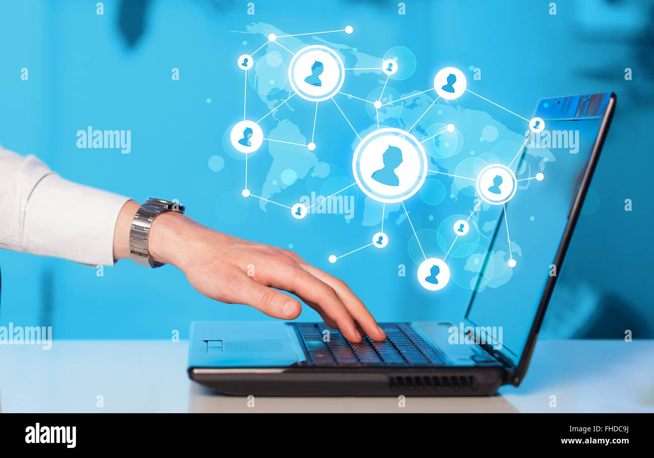 Close up of hand with laptop and social media icons Stock Photo - Alamy