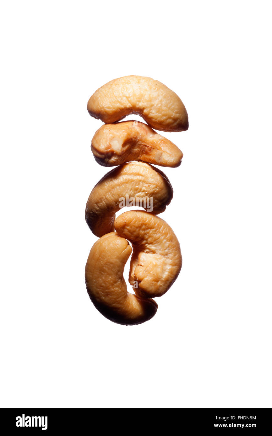 Five cashew nuts grouped together on a white background Stock Photo