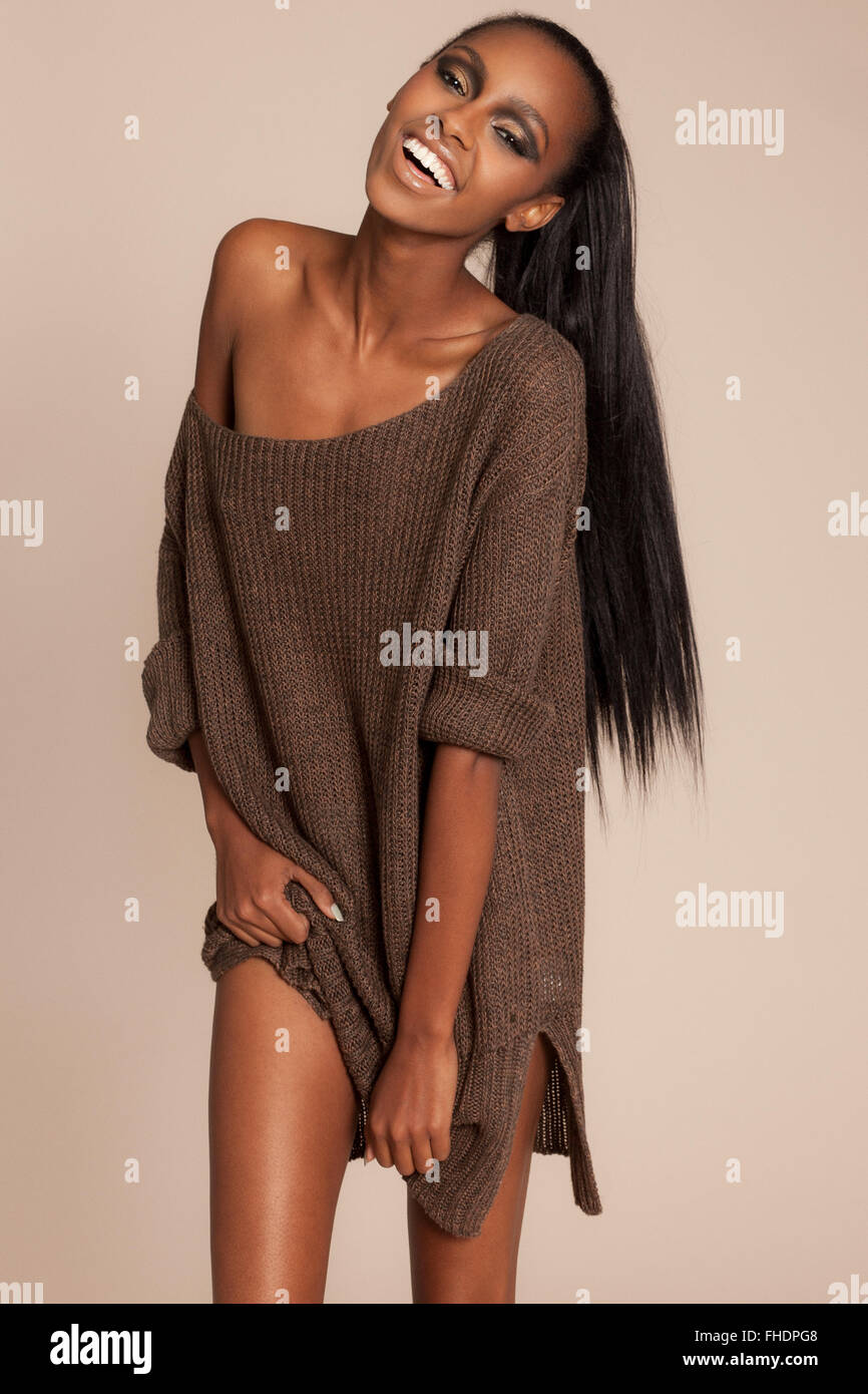 Young ethnic woman with large sweater showing skin Stock Photo