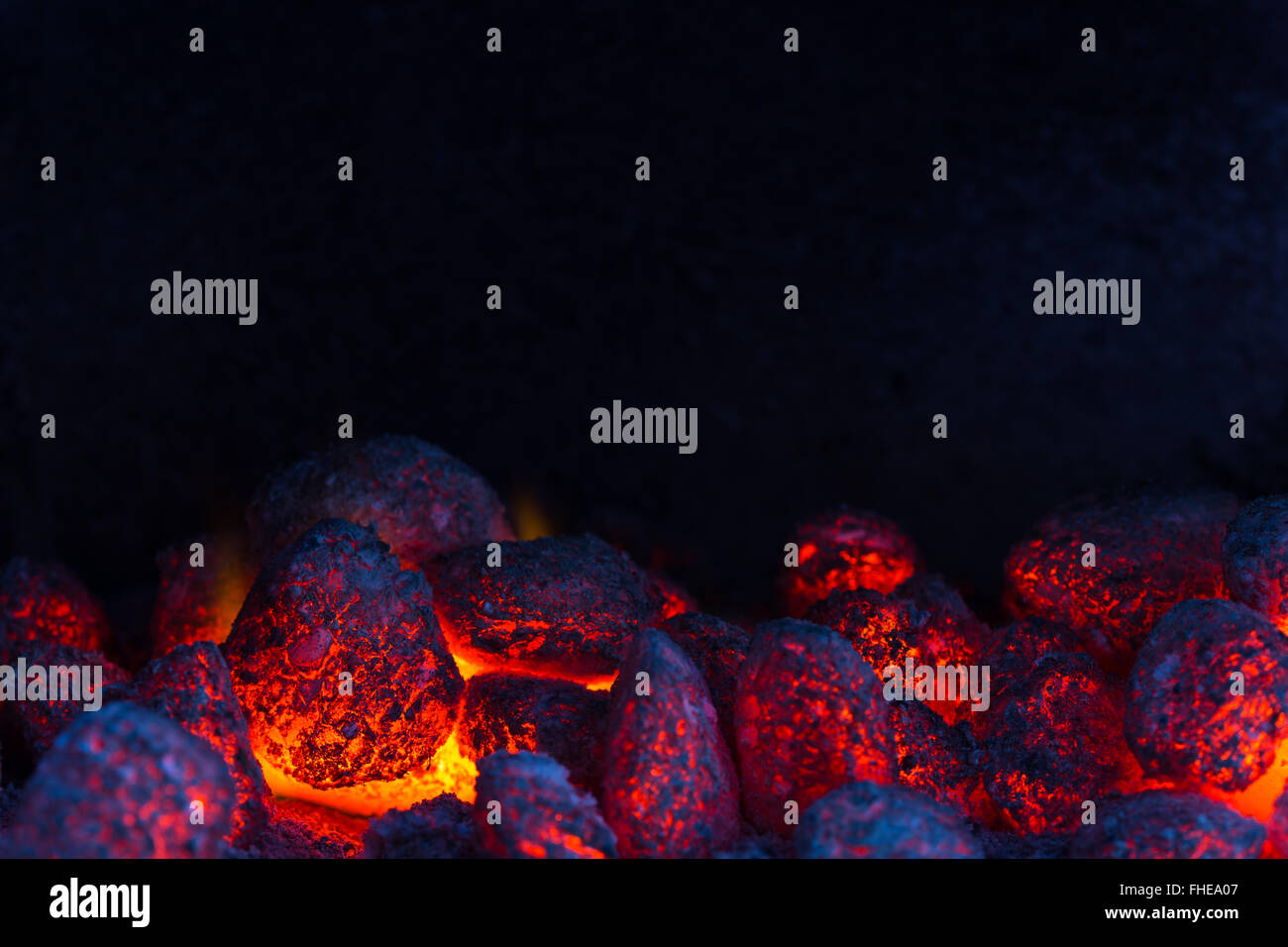glowing coal on a barbecue, closeup with copyspace at the top Stock