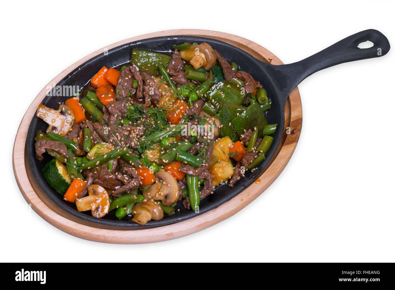 Roasted veal with mushrooms and vegetables in the iron pan, isolated with clipping path Stock Photo