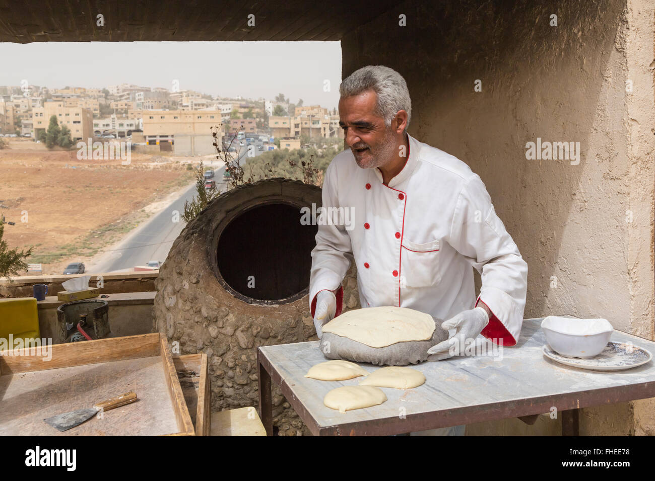 A Jordanian chef making flat bread at an outdoor oven in Jerash