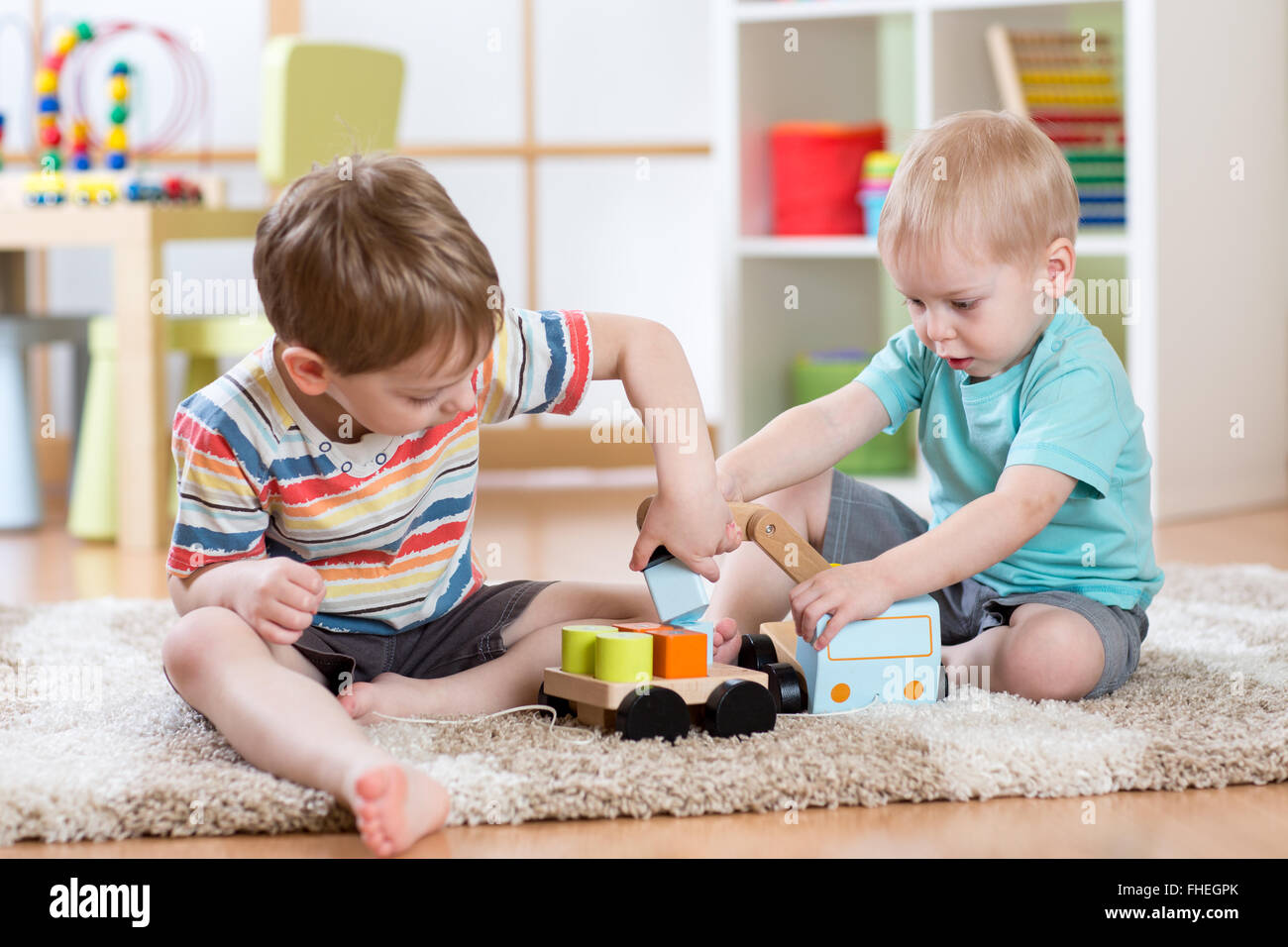 kids friends playing with crane car toy together Stock Photo