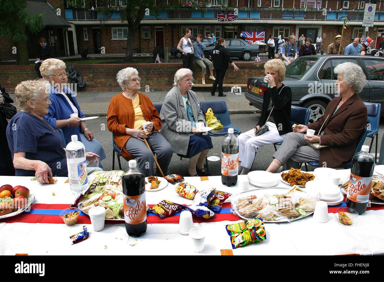 Residents at a special buffet during a Golden Jubilee street party in Jubilee Street in the Stepney Green area of east London, where hundreds turned out to celebrate the 50 year reign of Queen Elizabeth II. Celebrations took place across the United Kingdom with the centrepiece a parade and fireworks at Buckingham Palace, the Queen's London residency. Queen Elizabeth ascended to the British throne in 1952 upon the death of her father, King George VI. Stock Photo
