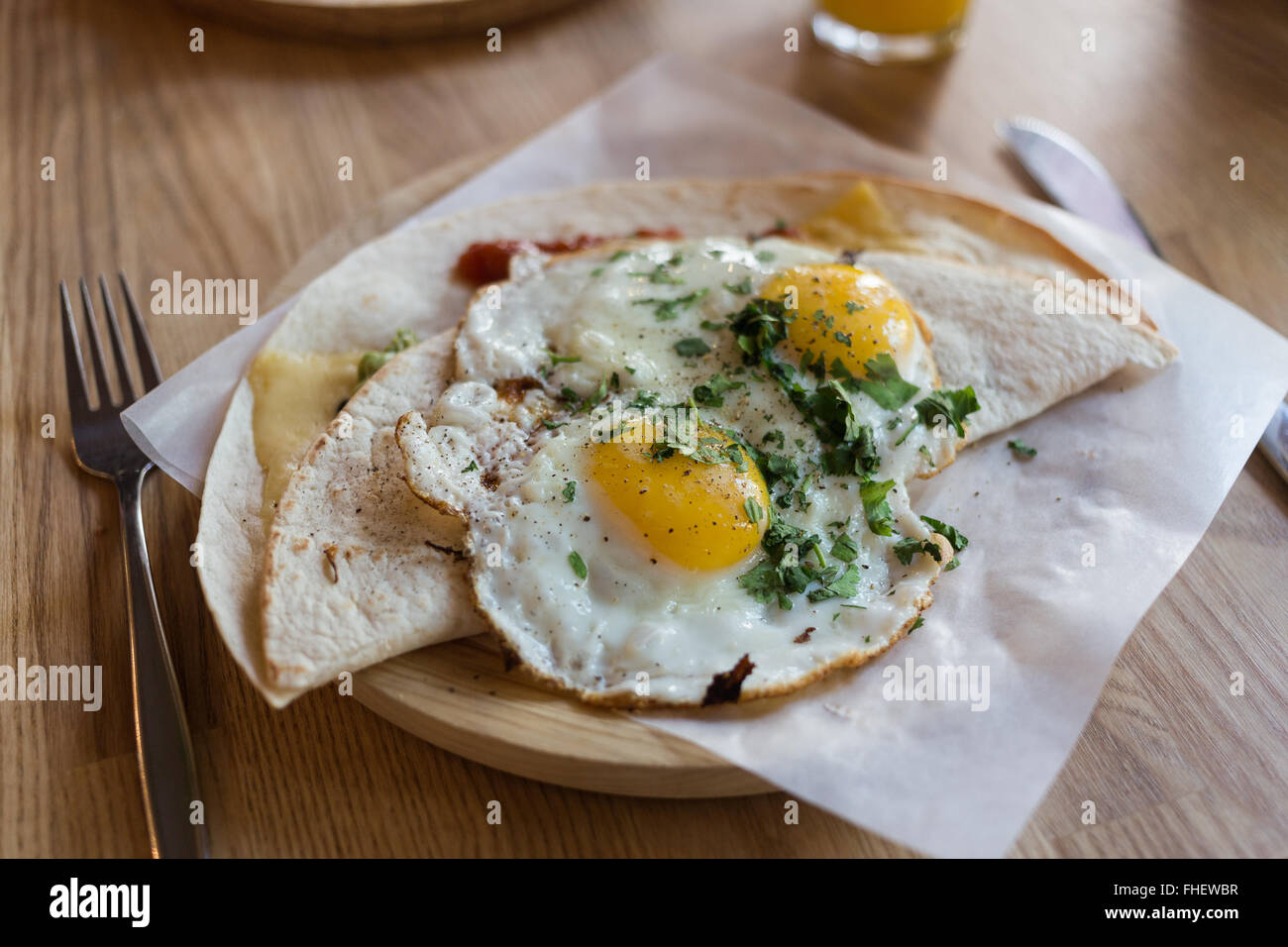 Fried eggs on a folded tortilla wrap with fresh seasoning. Served on a