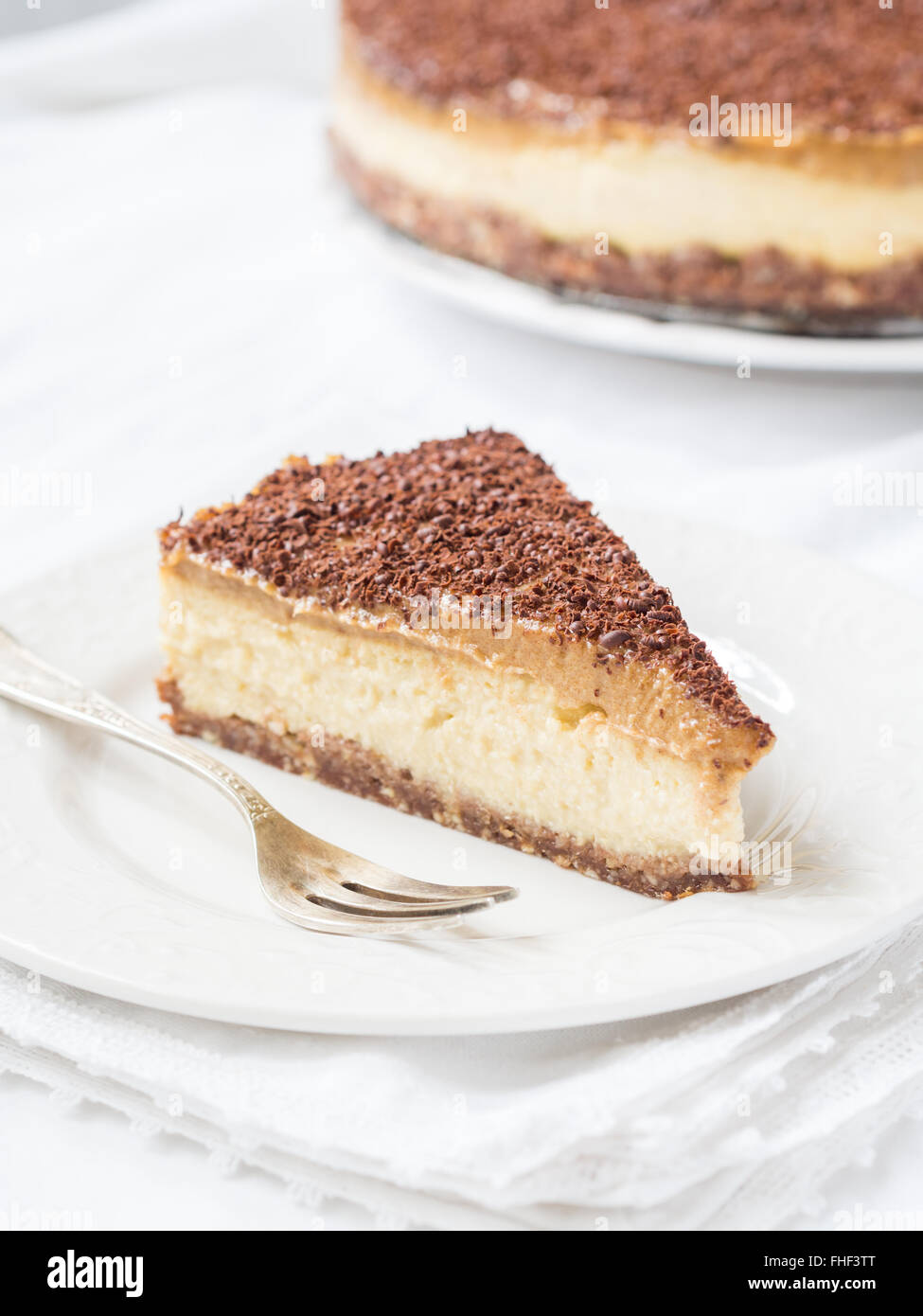 Slice of vegan millet cheesecake with date caramel on a cleat background. Stock Photo