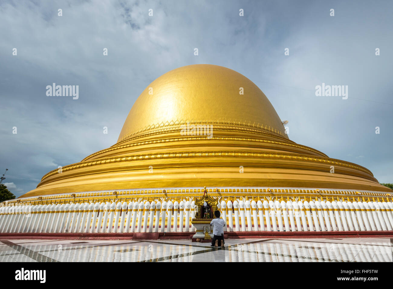 Praying man in front of Kaunghmudaw pagoda or Yaza Mani Sula Kaunghmudaw or Rajamanicula, Sagaing Region, Myanmar, Burma Stock Photo