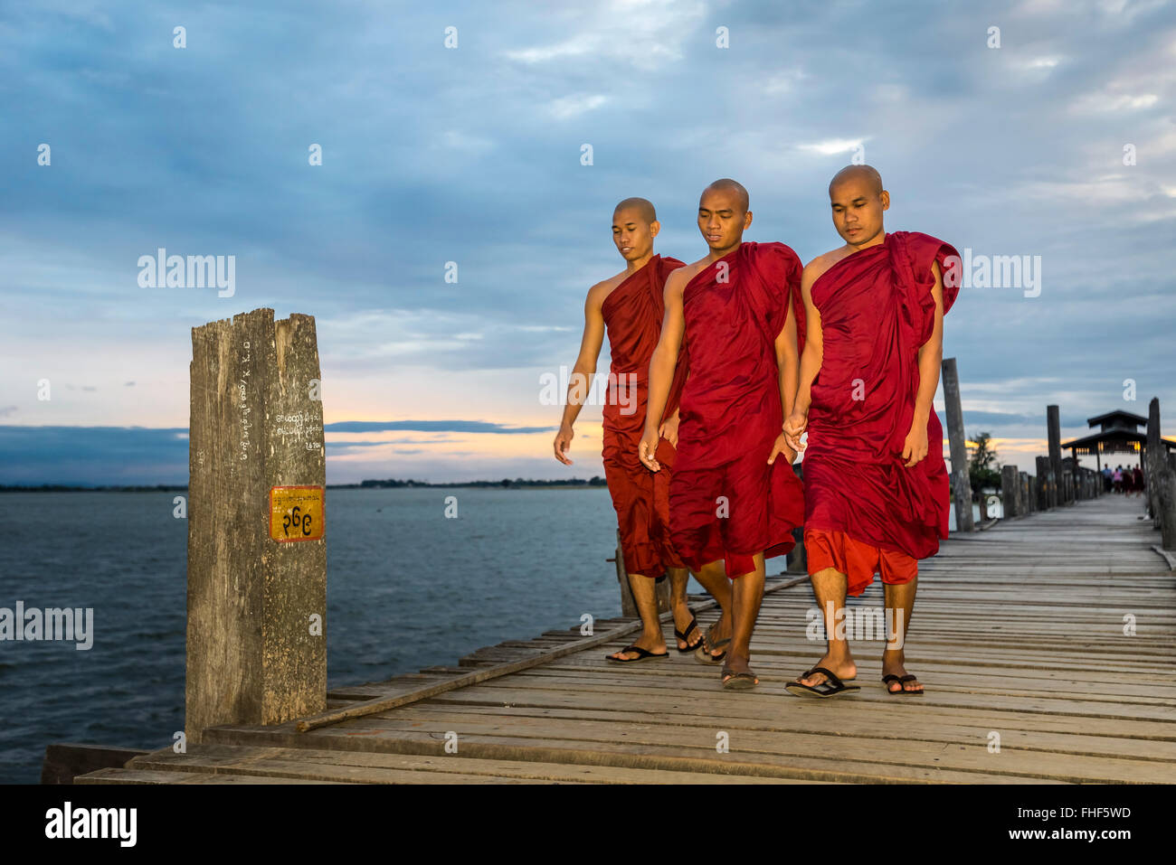 Monks on teakwood bridge, U Bein Bridge, Thaungthaman Lake, evening mood, Amarapura, Mandalay Division, Myanmar, Burma Stock Photo