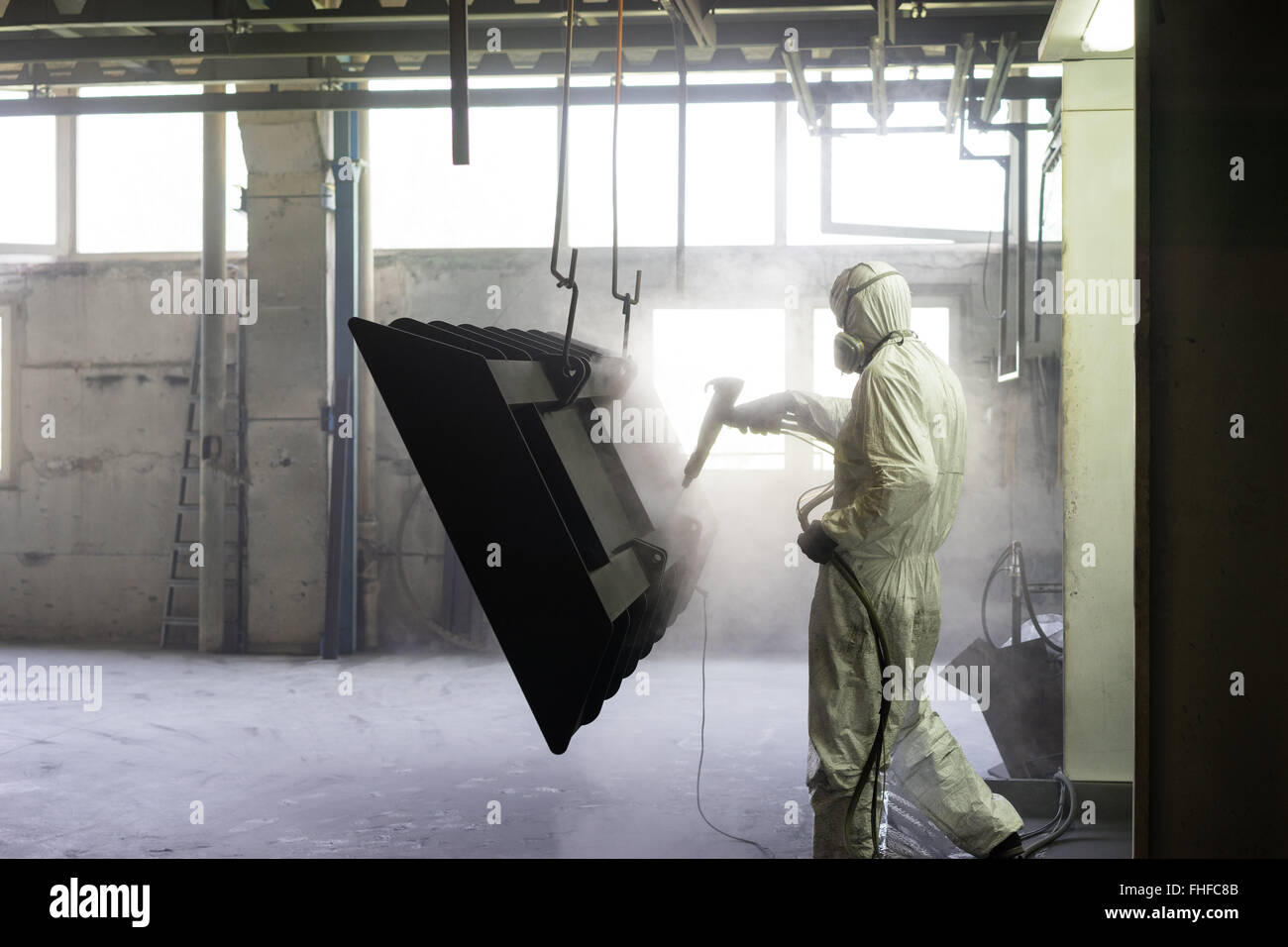 view of a worker wearing a full white protective suit and breathing