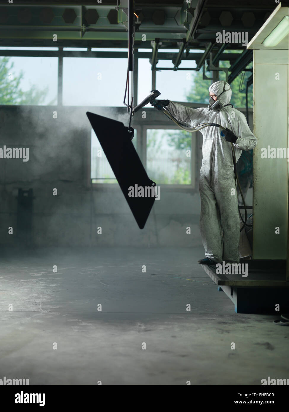 view of a worker wearing a full white protective suit and breathing