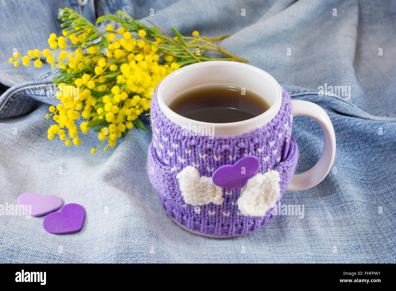 Winter cup of tea and mimosa flowers on blue denim background Stock Photo