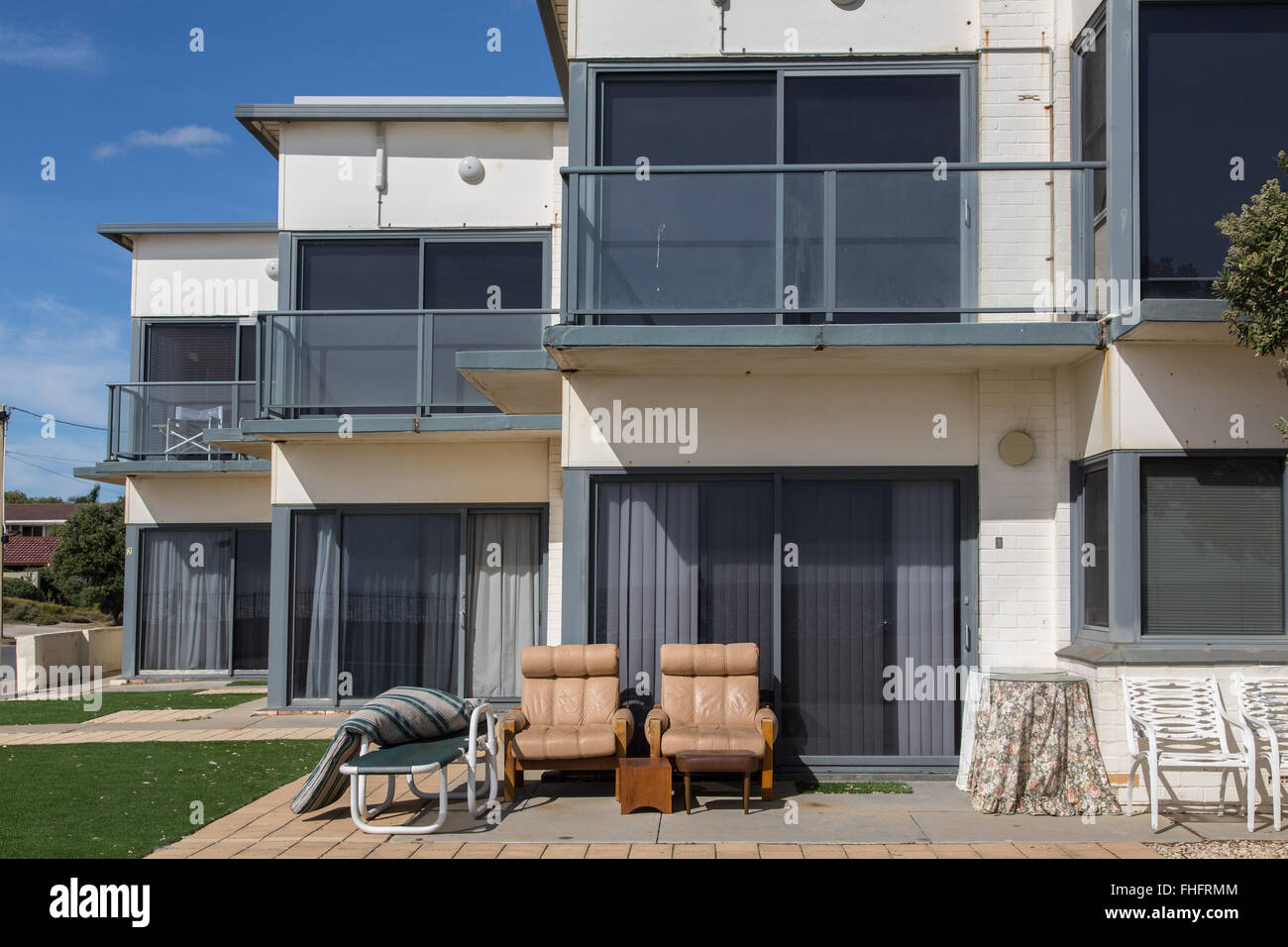 seaside apartments' terrace with furniture of different style exposed to sun, no occupants visible Stock Photo