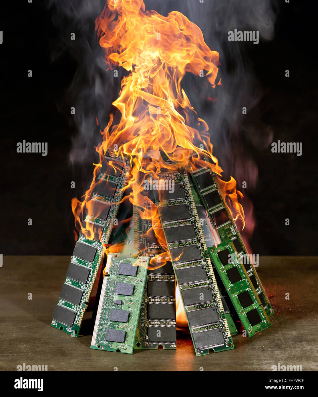 burning pile of random access memory sticks in front of dark back Stock Photo